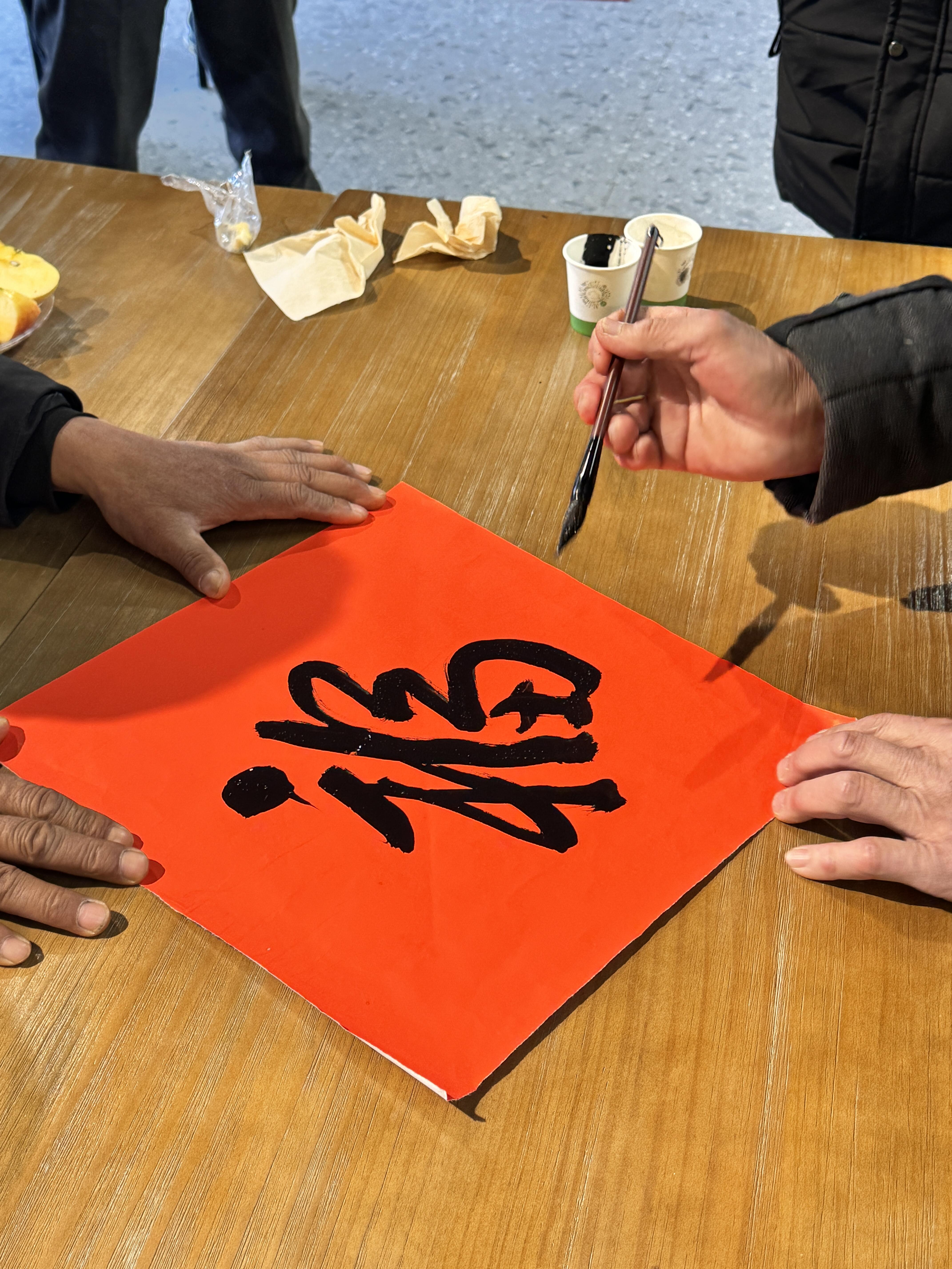 村民在少间梧桐下书写新年福字